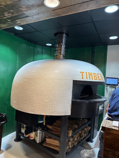 Wood-fired pizza oven at Timber Pizza Co., a commercial tenant at High Park Village in Raleigh, NC, managed by York Properties.