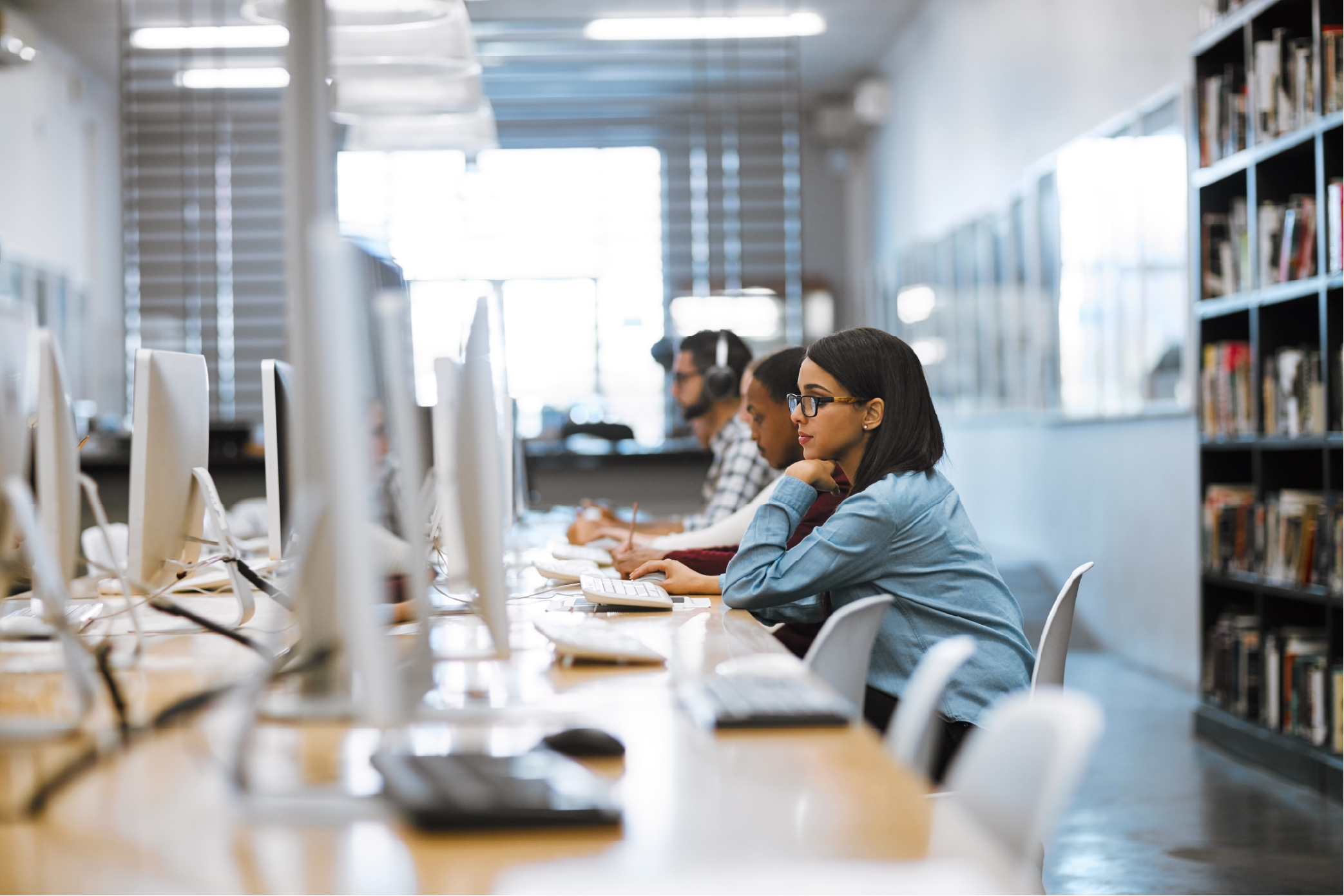 Students working at computers inside a modern research laboratory at a Raleigh university, highlighting the connection between academic research and local commercial real estate